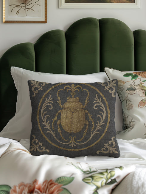 square woven tapestry pillow in charcoal grey and metallic gold thread, embodying a premium, artisan feel. The central design features a large, detailed scarab beetle, a key motif in entomology decor, encircled by ornate Victorian botanical flourishes. This combination of scholarly and mystical elements is ideal for Dark Academia, Gothic, and Whimsigoth aesthetics. The luxurious, double-sided piece of functional art is perfect as a statement pillow for a library or reading nook.